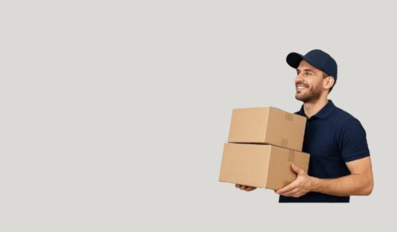 A cheerful delivery person in a navy blue uniform and cap holding two stacked cardboard boxes.
