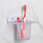 The Eskimo 2-in-1 Multipurpose Holder mounted on a white marble-patterned bathroom wall, holding a red toothbrush and a tube of toothpaste, to demonstrate its use.