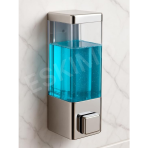 A close-up shot of the Eskimo Series-Z wall-mounted soap dispenser filled with blue soap, mounted on a white marble-like wall.