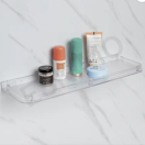 Angled view of the Eskimo clear bathroom shelf on a marble wall, showcasing its sleek design and storage capacity.